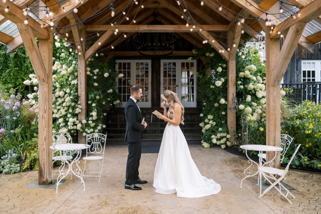 A couple exchanges vows under a beautifully decorated wooden gazebo.